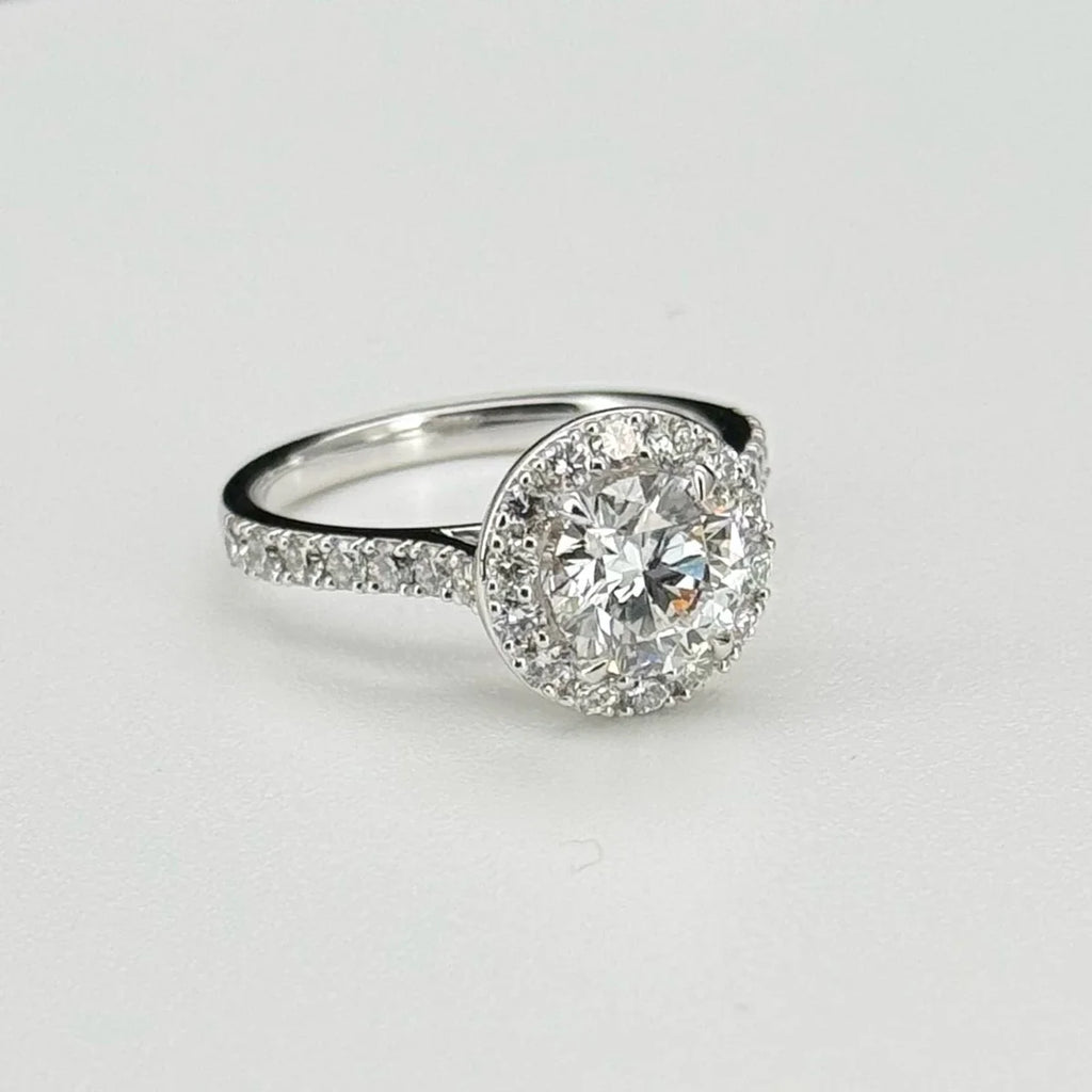 Diamond ring with a halo on a light gray background